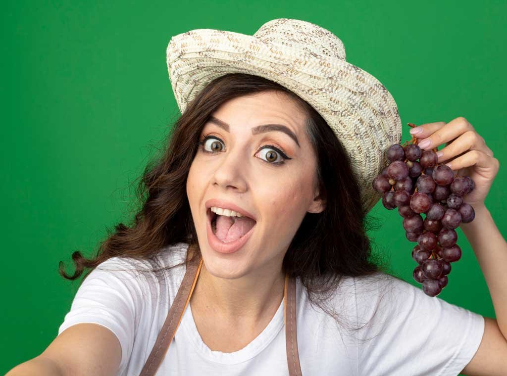 girl with bunch of grapes with happy face